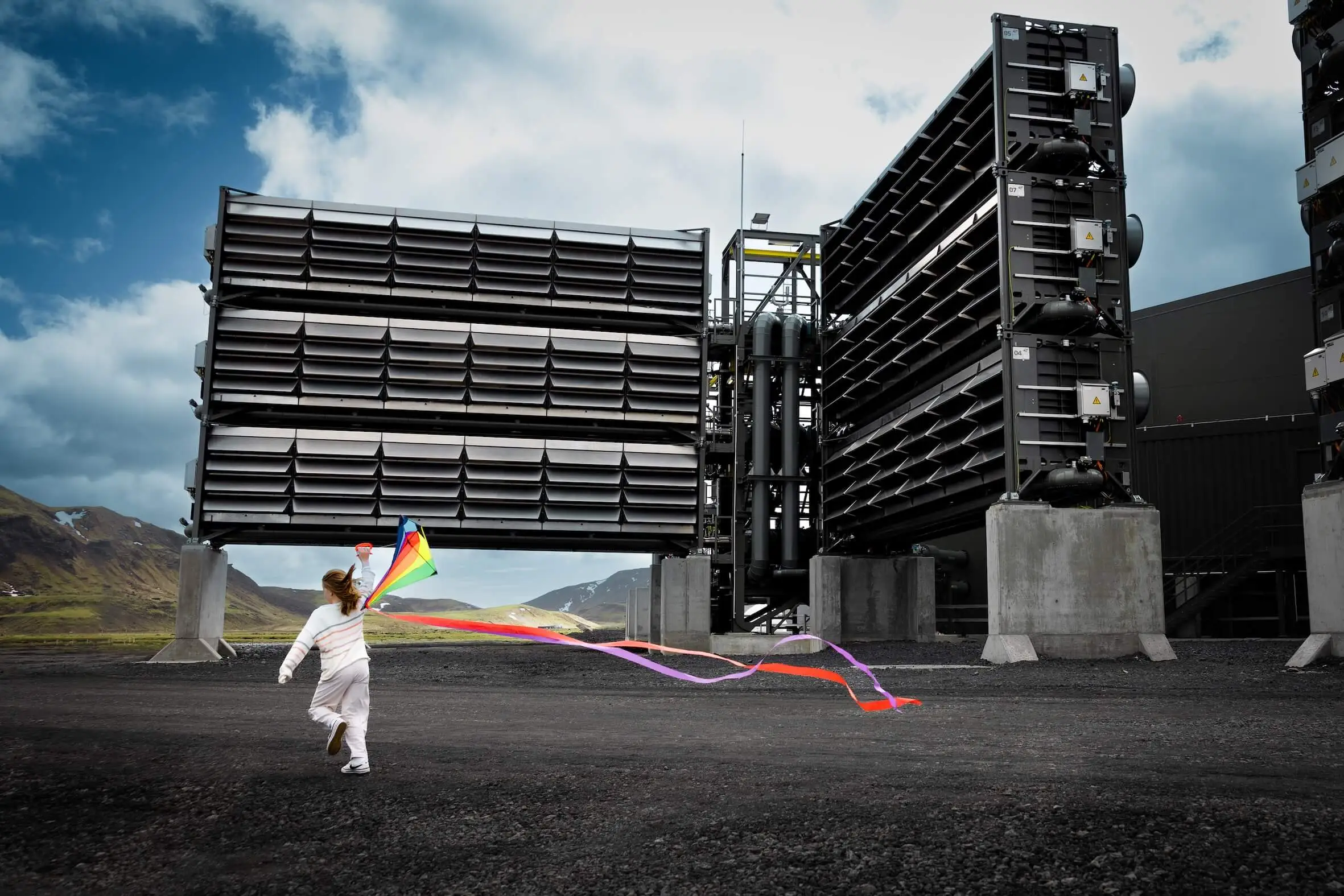 Climeworks' Mammoth direct-air-capture plant in Hellisheiði, Iceland — industrial-scale machines pulling CO₂ directly from the atmosphere, photographed at the plant's 2024 unveiling with a child flying a kite nearby.